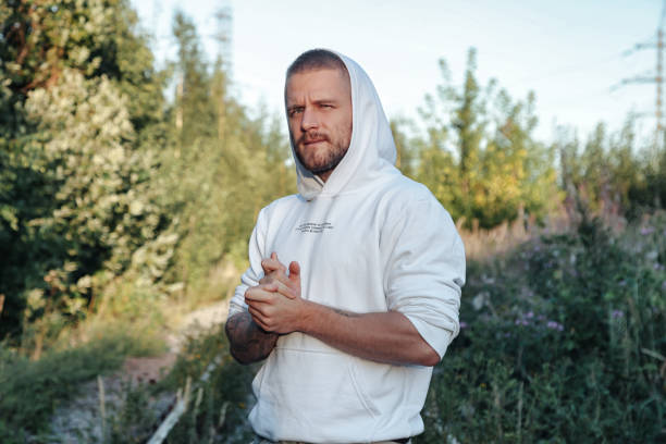 Bearded jewish guy in white jacket taking handshake at forest, looking at camera. Man spending summertime in countryside outdoor. Lifestyle concept walking in fresh air on nature. Copy ad text space chico judío barbudo con chaqueta blanca dando un apretón de manos en el bosque, mirando a la cámara. hombre que pasa el verano en el campo al aire libre. concepto de estilo de vida caminando al aire libre en la naturaleza. copiar el espacio de texto del