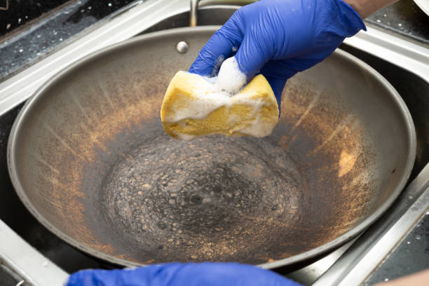 istock man cleaning a dirty cooking pan at horizontal composition 1471087446