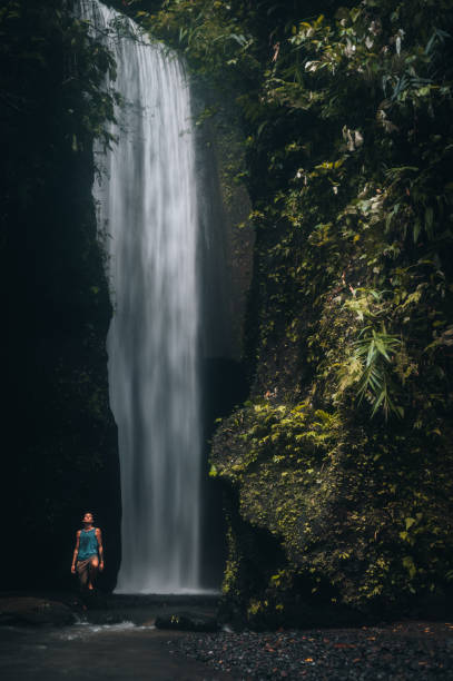 istock Man admiring waterfalls in Bali, Indonesia. 1471099411