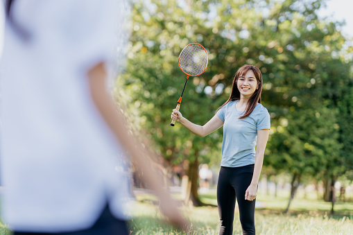 Mother and daughter playing badminton at public park