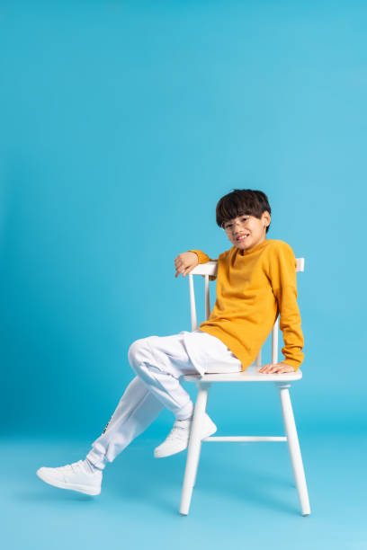 istock Portrait of sitting boy, isolated on blue background 1471106959