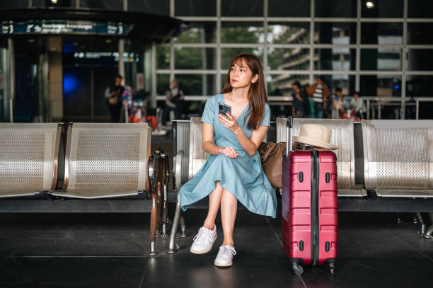 istock An Asian woman checking her smart phone while waiting for taxi 1471106984