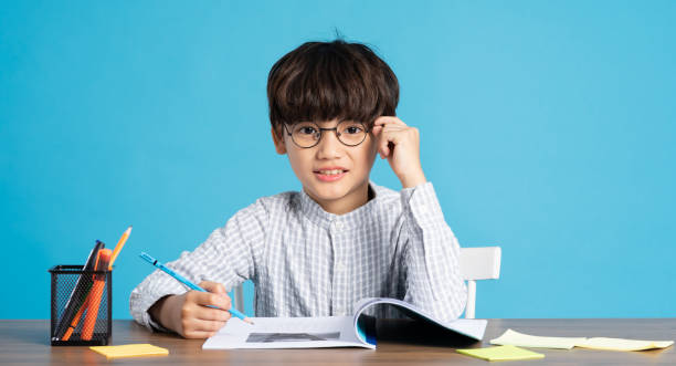 istock portrait of school boy sitting and studying on a blue background 1471107902