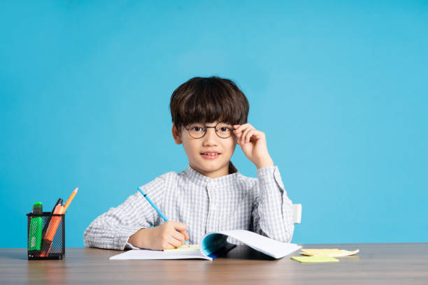 istock portrait of school boy sitting and studying on a blue background 1471107914