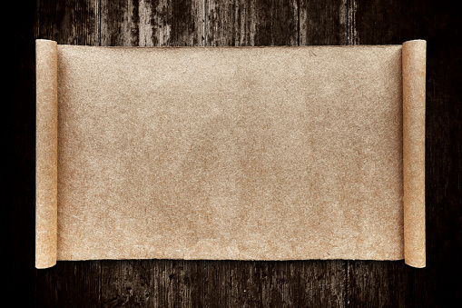 Blank brown scrolling paper on wood background.