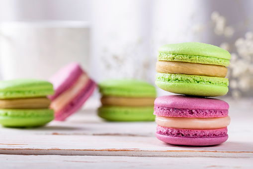 Pink and green macaroons close-up on a light background. French almond biscuits photographed very tasty
