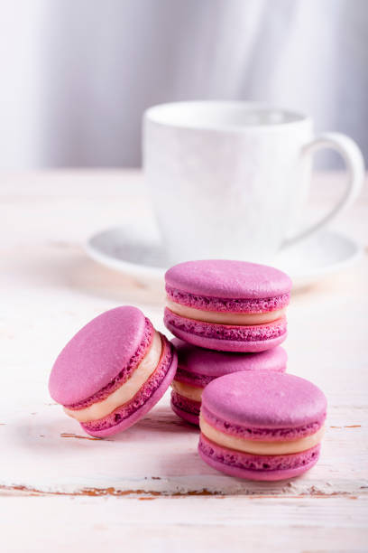 istock three pink macaroons and a white cup of coffee on a wooden table 1471112554