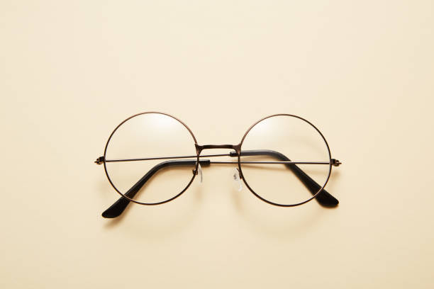 istock Glasses in round thin metal frame isolated on beige surface. 1471114640