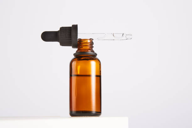 istock Black cap with pipette lies on open brown glass bottle. 1471115531
