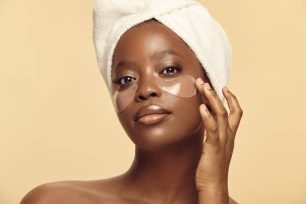 istock Beautiful afro ethnicity woman using eye patches on a beige background. 1471116053