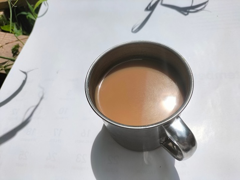 warm chocolate milk in an iron cup on a white background