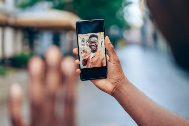 istock Young smiling man using smartphone on the street. 1471122909