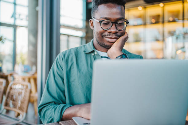 istock Young man sitting in coffee shop and using laptop. 1471122910