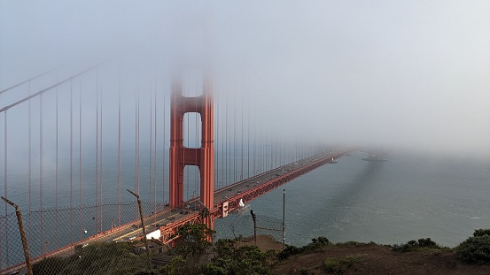 Marin tower of the Golden Gate Bridge with San Francisco in the background. The famous Transamerica Building visible through the tower.Similar shots: