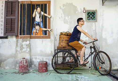 George Town, Malaysia - Aug 21, 2014. An unidentified tourist having fun on the central street of George Town, Penang, Malaysia.