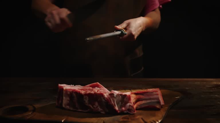 Chef sharpening knife in front of cutting table