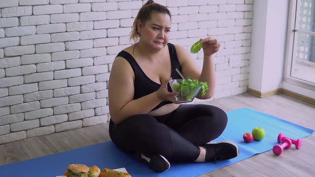 Overweight woman boring eat salad