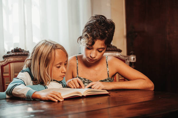 Brother and sister studying on a book