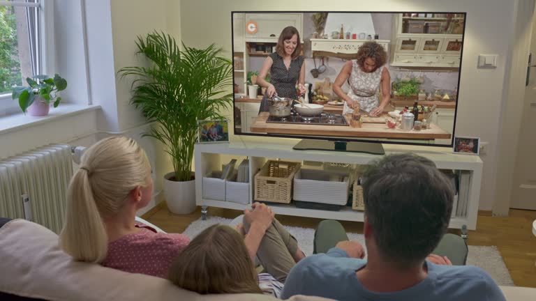 DS Family sitting on the sofa and watching a cooking show