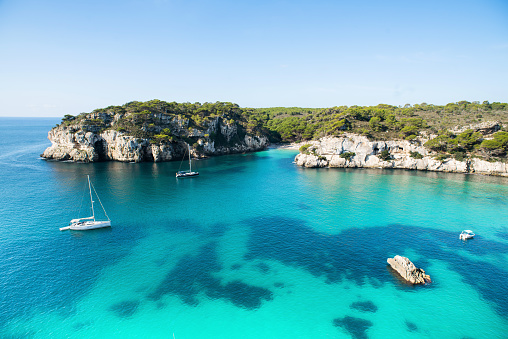 Beautiful view of bay with sailing boat at the seaside of Porto Cristo on Mallorca, Spain Mediterranean Sea