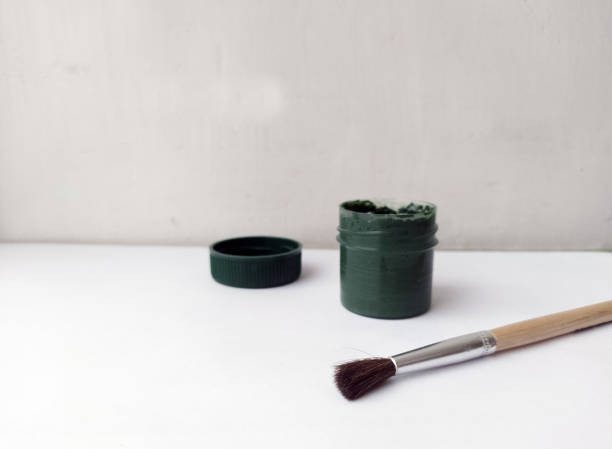 istock Brush and can with dark paint on a white background. The paint is open. Everything for drawing. Creation. Children are creativity. Hobby. Colored paints and gouache. 1471144492