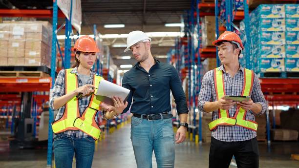 istock Businessman owner discussing with workers while walking through large warehouse distribution center in shelves with goods background. Logistic industry concept 1471147146