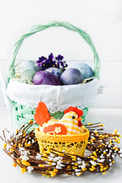 istock Easter eggs in a wicker basket on a white background. Decorative chicken with Easter eggs. Easter composition with space for text 1471149336