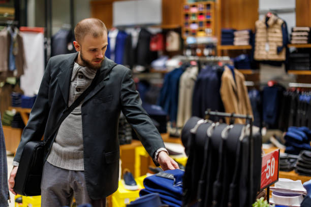 istock A young elegant man is choosing clothes in a supermarket store. 1471154006