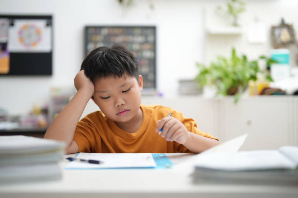 istock Boy sitting at desk concentrating on homework for his exams. 1471154315