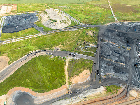Coal facility with trucks driving in, drone view