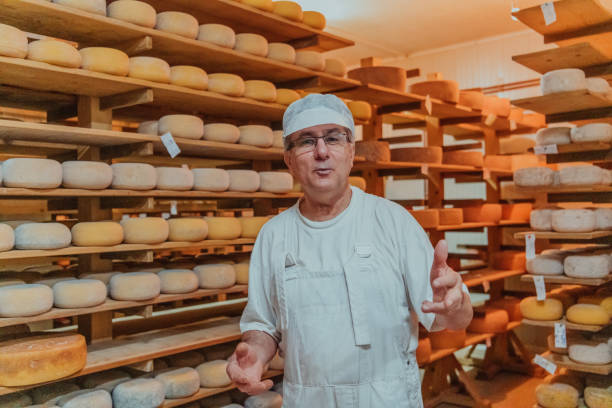 istock A worker at a cheese factory sorting freshly processed cheese on drying shelves 1471159191