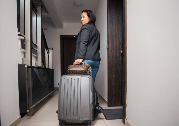 istock Woman with suitcase in hallway 1471161759