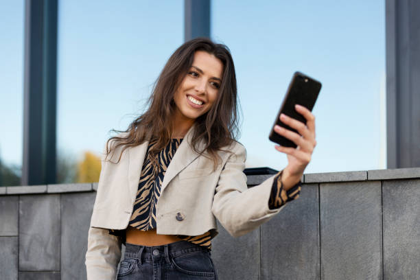 istock Attractive, young girl taking a selfie on a mobile phone. A beautiful influencer communicates with her followers, records videos. 1471166521