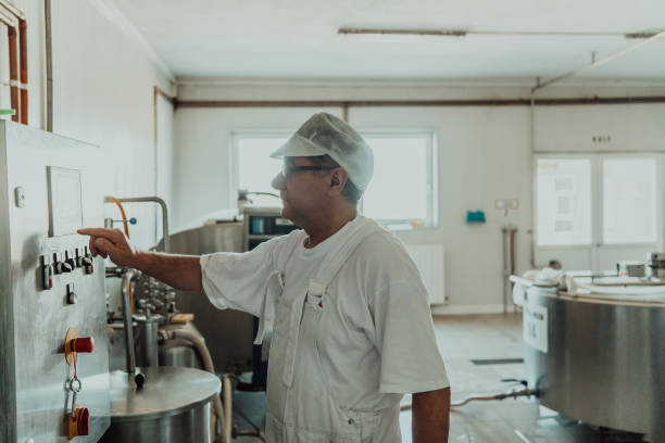 istock Cheese maker working in the modern industry on machines that are using for the machining of fresh cheese 1471166650