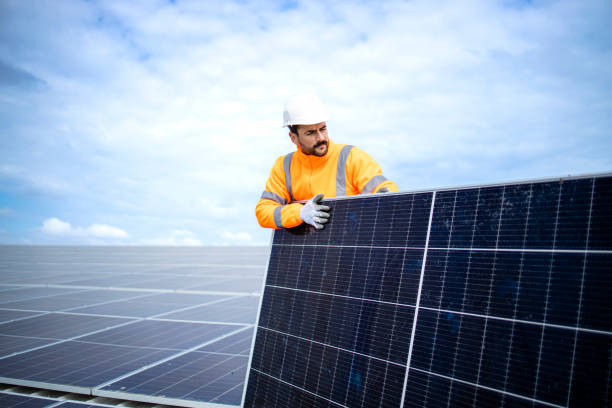 istock Installing solar power plant as sustainable energy source. Worker placing solar panel on the roof. 1471168173