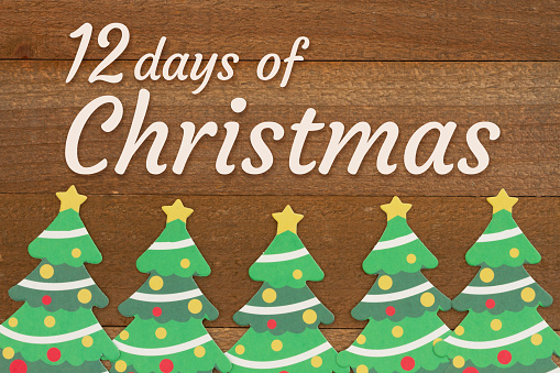 12 days of Christmas greeting with Christmas trees on weathered wood