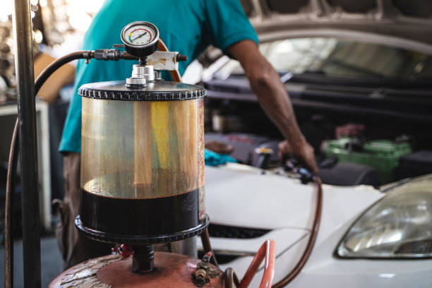 механический всасывание масла из двигателя в гараже. - old men car oil стоковые фото и изображения