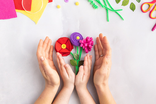 Handmade felt flowers craft with kids women's mother's day gift present hands. High quality photo