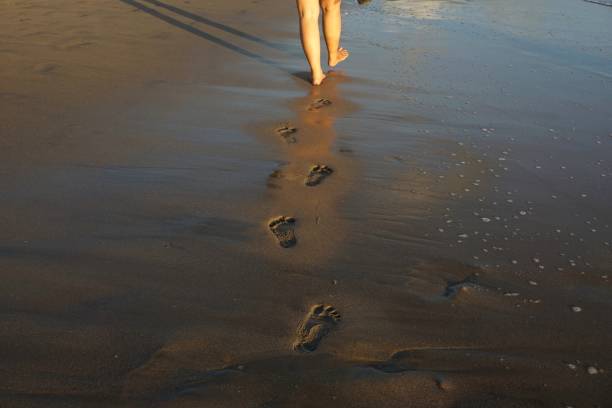 istock footprints in the beach sand and waves 1471176722