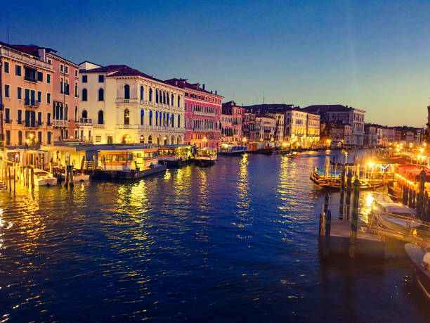 Venice, Italy - August 31st, 2019: Grand Canal, old buildings and Basilica di Santa Maria della Salute in Venice, Italy at dusk