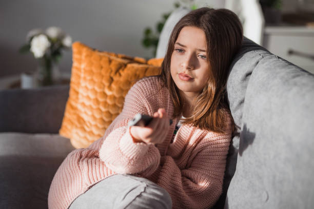istock Serious young girl watching TV 1471179772