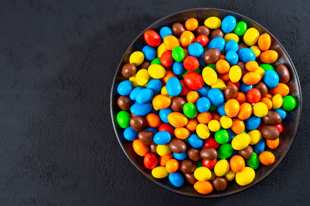 istock Multi-colored round candies in colored glaze in large quantities in a plate 1471180114