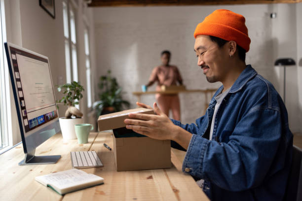 Happy Asian men packaging orders at his home office