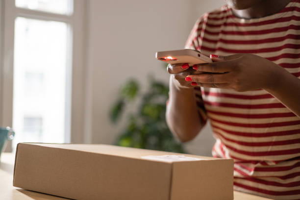 istock Unrecognisable black woman scanning QR code on package with her smartphone 1471182628