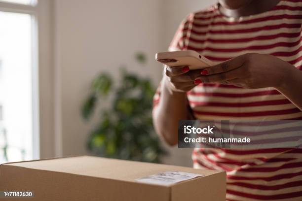 Unrecognisable Black Woman Scanning Qr Code On Package With Her Smartphone Stock Photo - Download Image Now