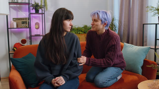 Two offended disappointed lesbian women family couple ignoring each other after quarreling at home