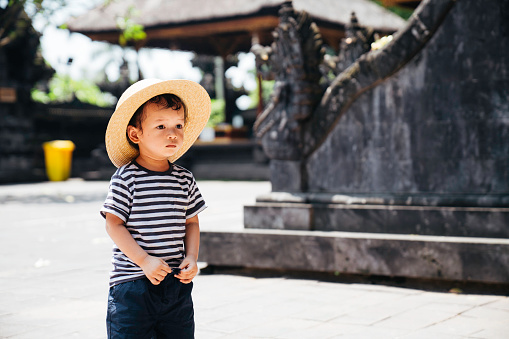 white toddler playing and visiting a Pura in Bali