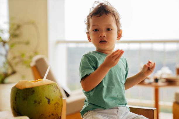 a male toddler is drinking coconut water - bali male beautiful ethnicity imagens e fotografias de stock