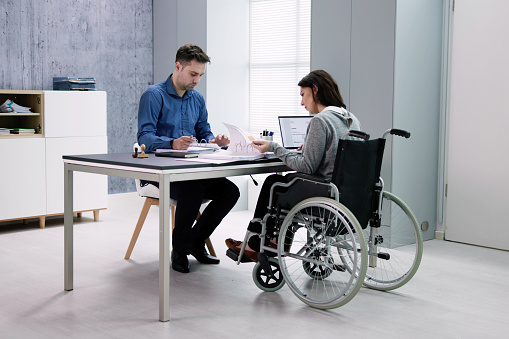 Businesswoman ith Disability Sitting On Wheelchair In Office
