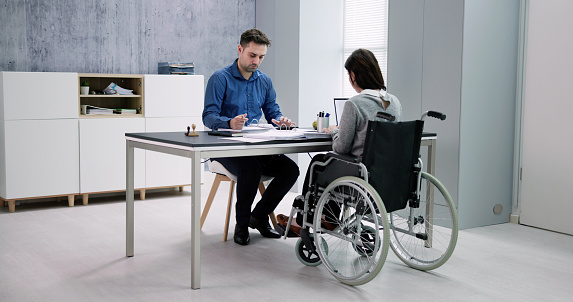 Businesswoman ith Disability Sitting On Wheelchair In Office